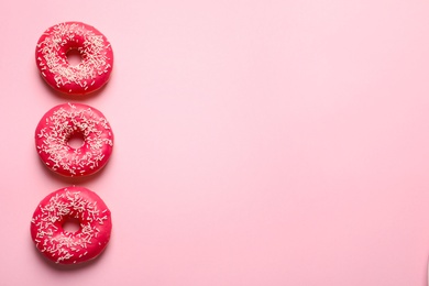 Delicious glazed doughnuts on color background, top view