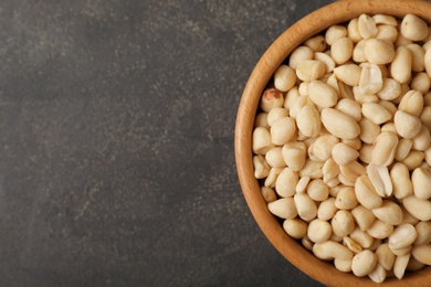 Shelled peanuts in bowl and space for text on table, top view