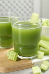 Photo of Celery juice and fresh vegetable on table, closeup