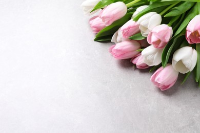 Photo of Beautiful pink spring tulips on light background, above view. Space for text