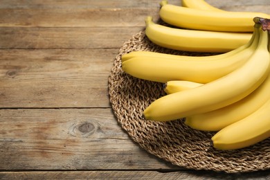 Ripe sweet yellow bananas on wooden table. Space for text