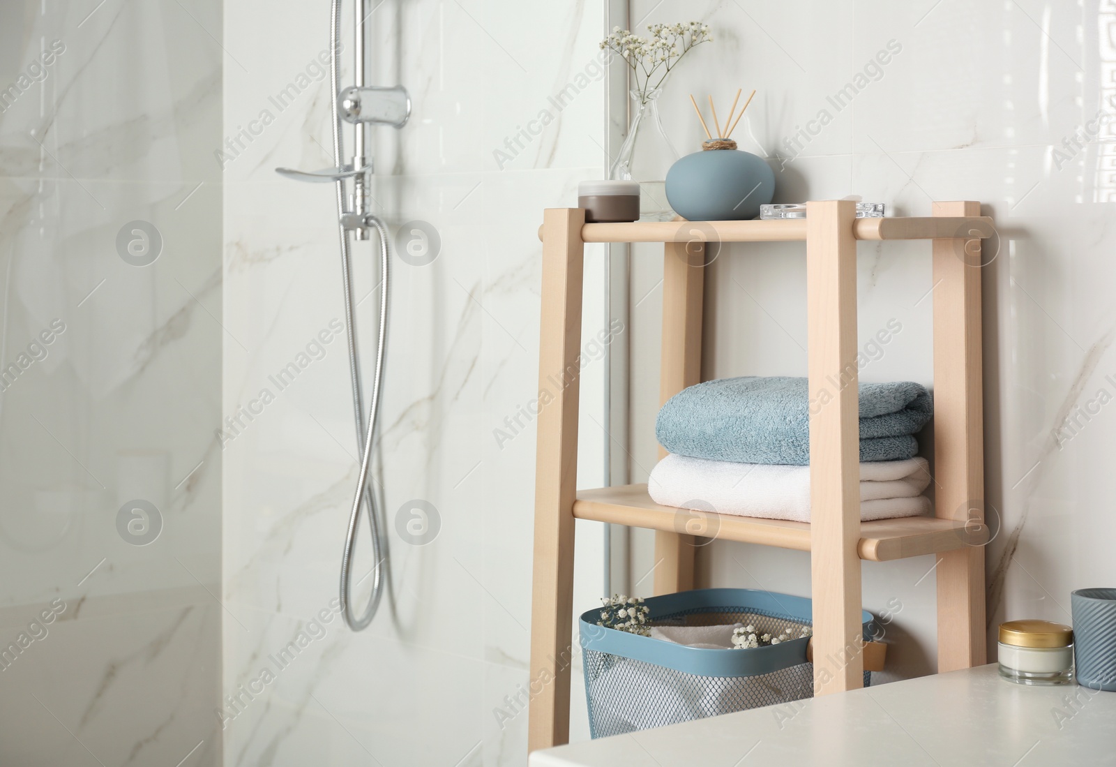 Photo of Shelving unit with clean towels in bathroom interior