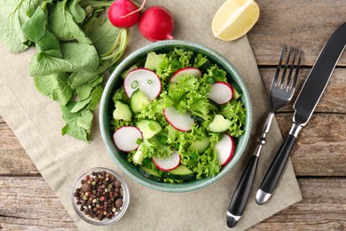 Photo of Delicious salad with radish served on wooden table, flat lay