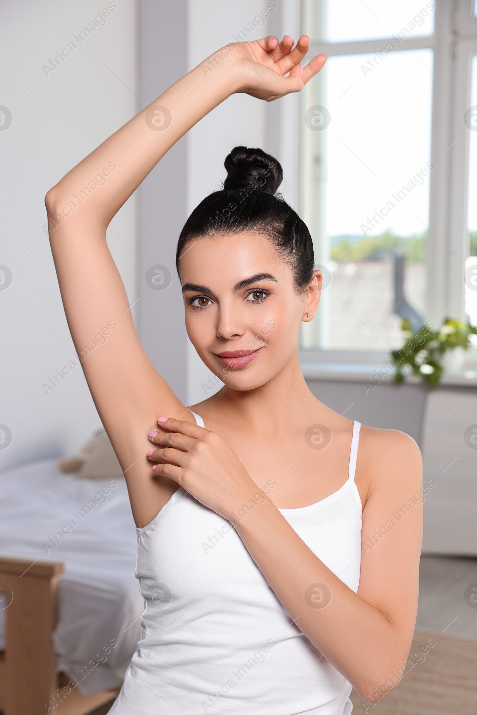 Photo of Young woman showing smooth skin after epilation indoors