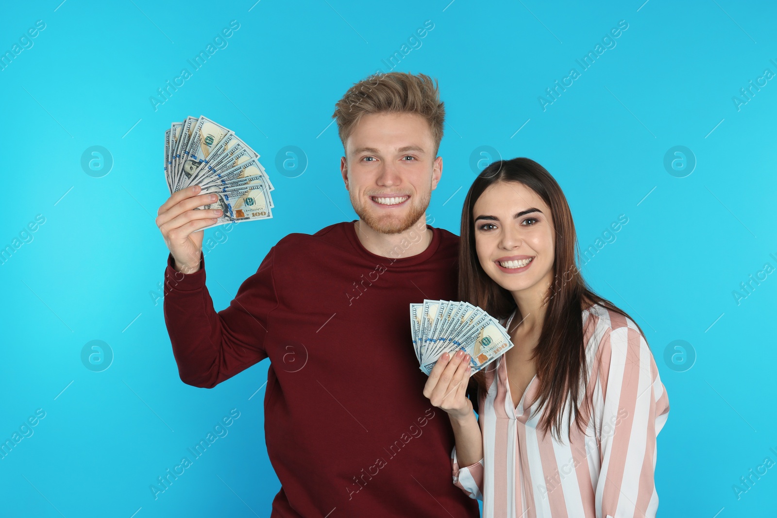 Photo of Young couple with money on color background