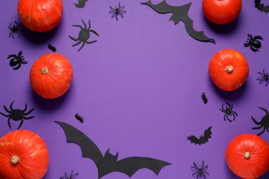 Frame made with Halloween decor on purple background, flat lay. Space for text