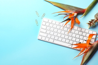 Photo of Creative flat lay composition with tropical flowers and computer keyboard on color background