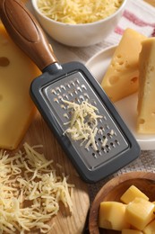 Grated, cut cheese and grater on table, closeup