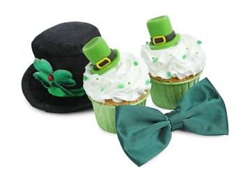 Photo of St. Patrick's day party. Tasty festively decorated cupcakes, green bow tie and leprechaun hat, isolated on white