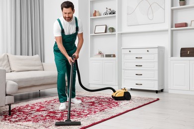 Photo of Dry cleaner's employee hoovering carpet with vacuum cleaner in room