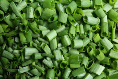 Cut green spring onions as background, closeup