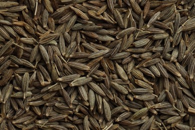 Aromatic caraway seeds as background, top view