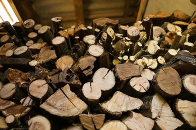 Stacked firewood indoors, low angle view. Heating house in winter