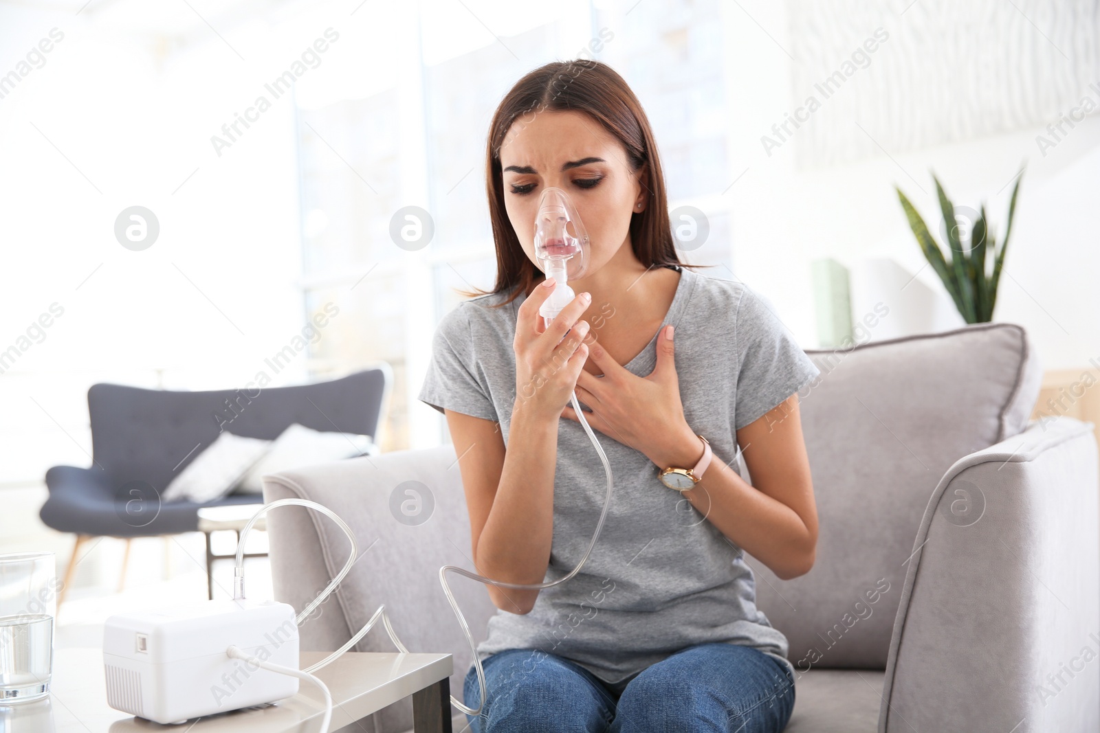 Photo of Young woman with asthma machine in light room