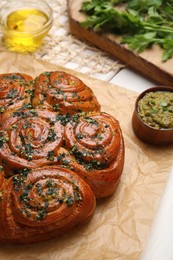 Traditional pampushka rolls with garlic and herbs on table, closeup