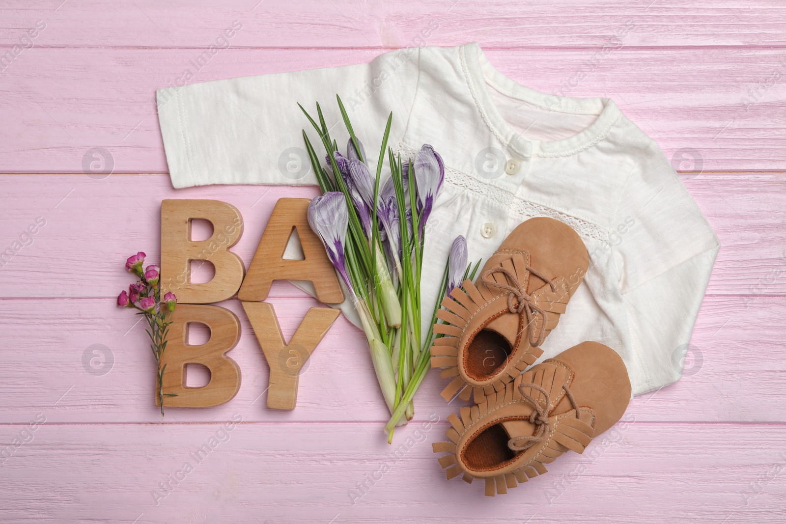 Photo of Flat lay composition with child's clothes on pink wooden table