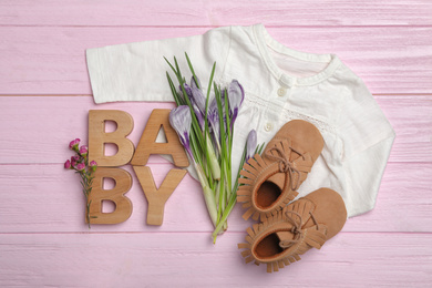 Flat lay composition with child's clothes on pink wooden table
