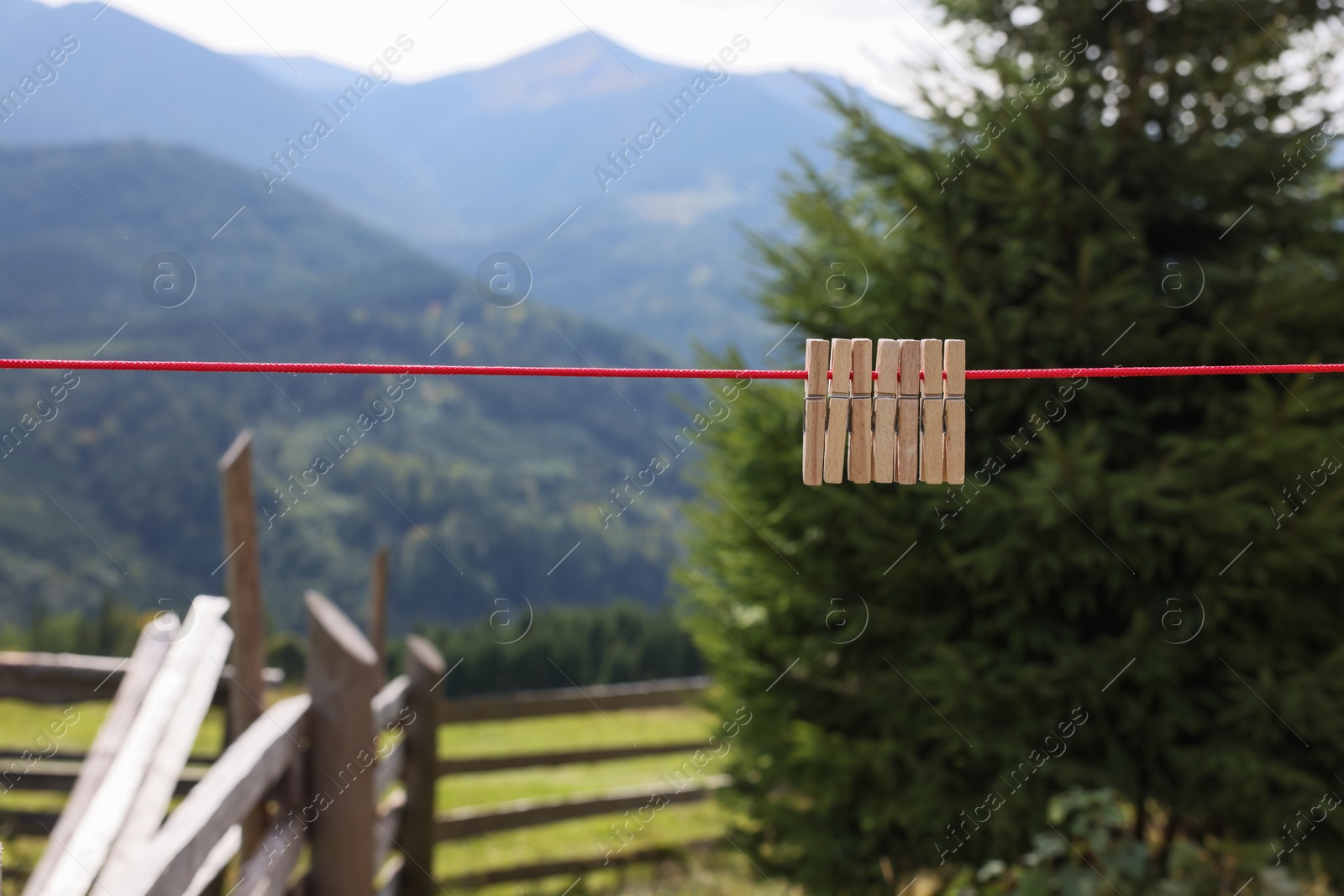 Photo of Wooden clothespins hanging on washing line in mountains