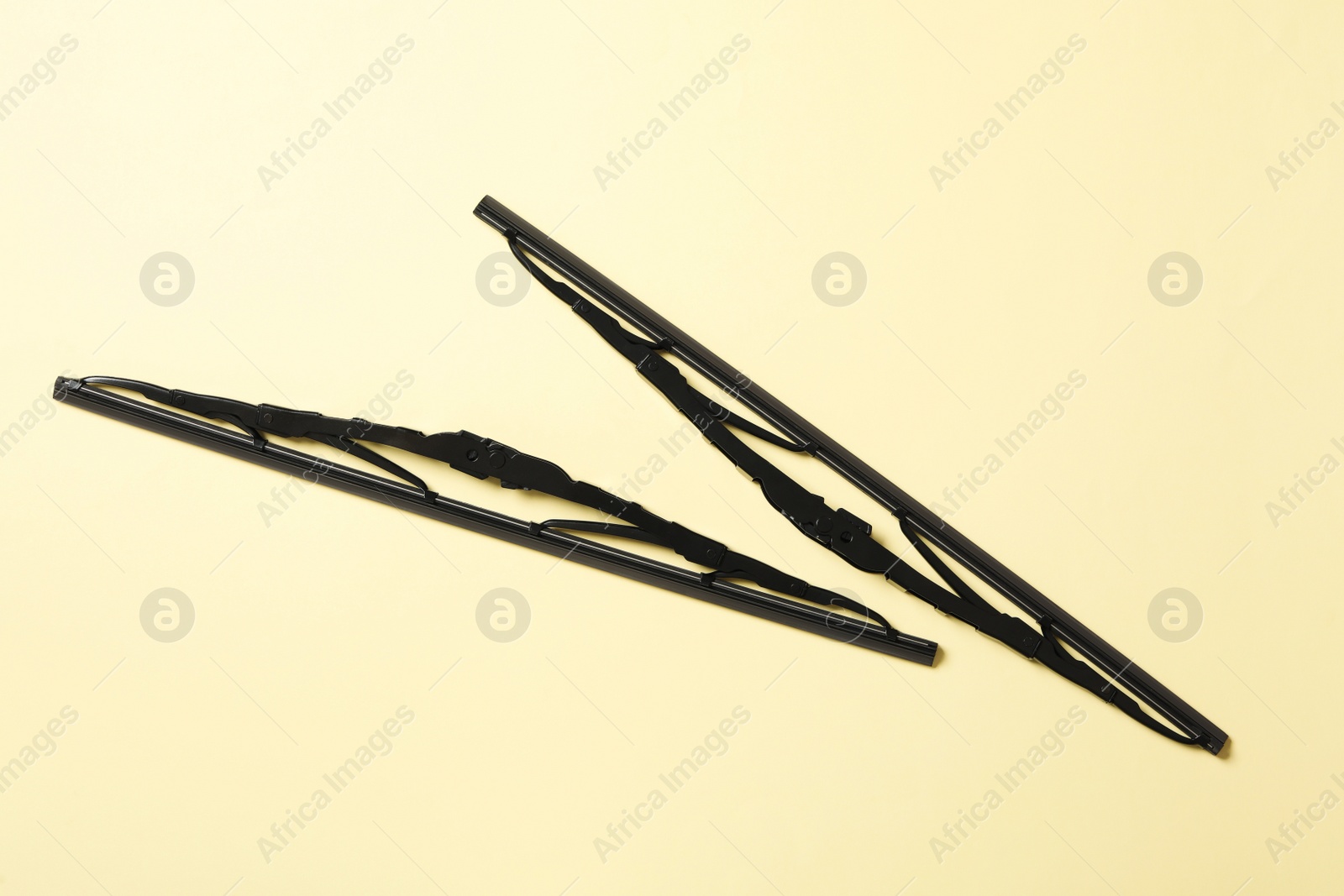 Photo of Car windshield wipers on beige background, flat lay