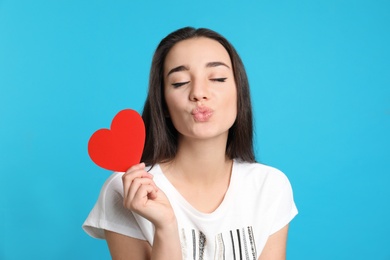 Photo of Portrait of beautiful young woman with paper heart on color background