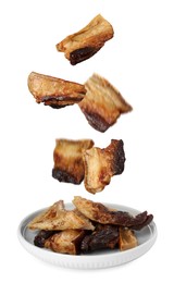 Image of Tasty fried pork lard falling into plate on white background 