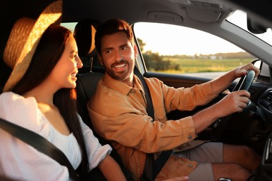 Happy couple enjoying trip together by car