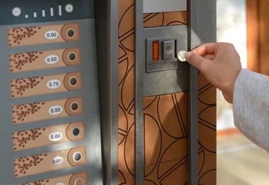 Image of Using coffee vending machine. Woman inserting coin to pay for drink, closeup