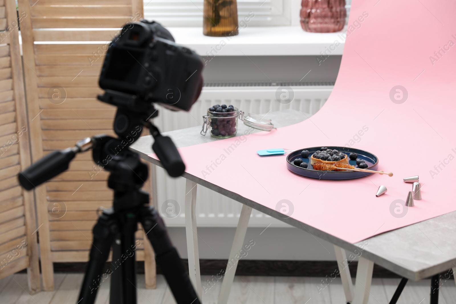 Photo of Professional equipment and composition with delicious dessert on pink background in studio. Food photography