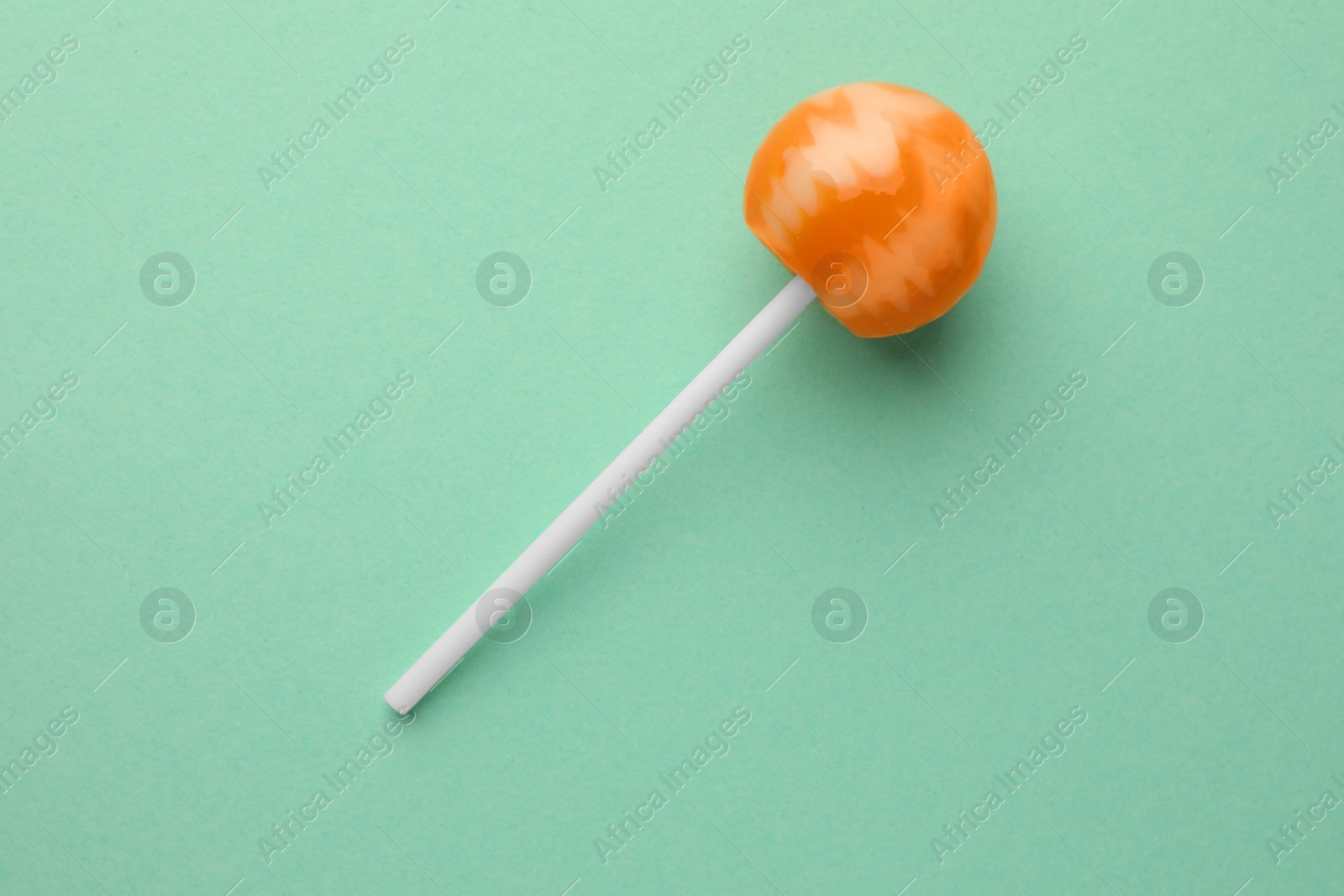 Photo of Tasty lollipop on turquoise background, top view