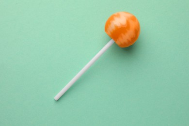 Tasty lollipop on turquoise background, top view