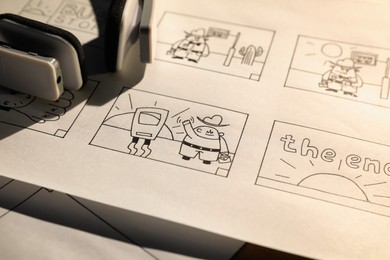 Storyboard with cartoon sketches at workplace, closeup. Pre-production process