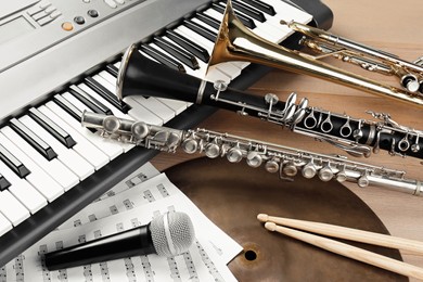 Photo of Set of different musical instruments and microphone on wooden background, closeup