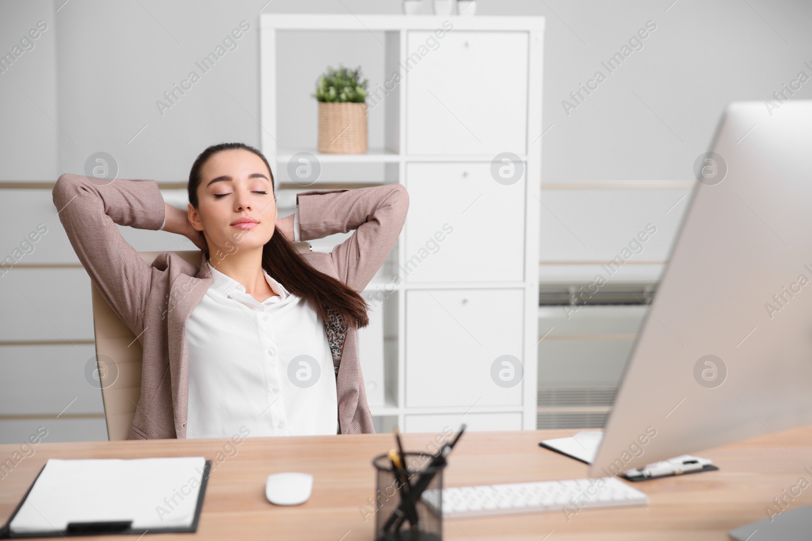 Photo of Young woman relaxing in office chair at workplace