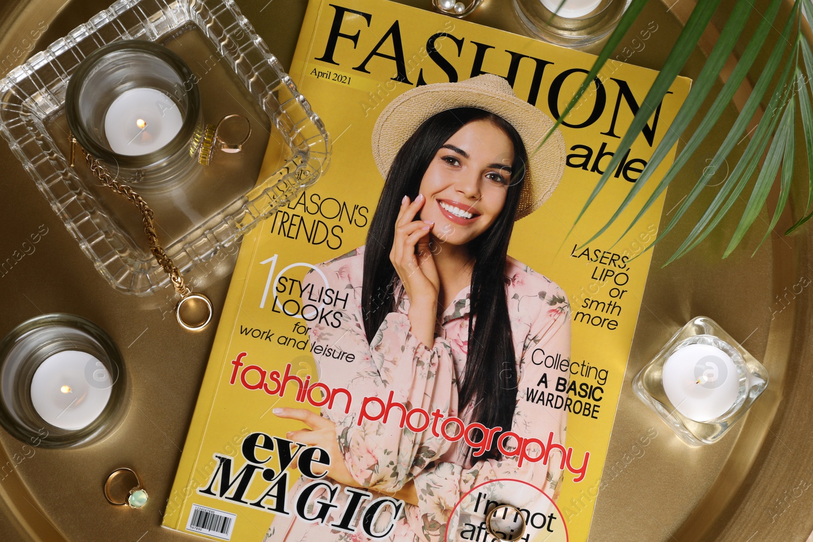 Photo of Fashion magazine, jewelry and candles on table, flat lay