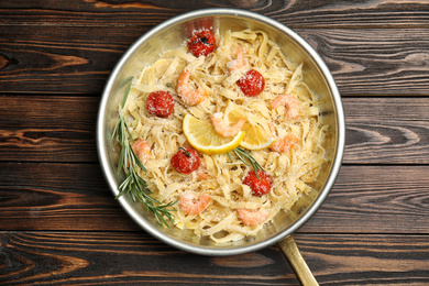 Delicious pasta with shrimps on wooden table, top view