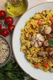 Delicious pilaf and products on table, flat lay