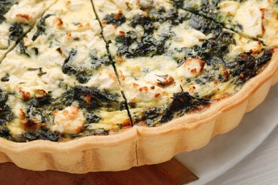 Delicious homemade spinach quiche on table, closeup