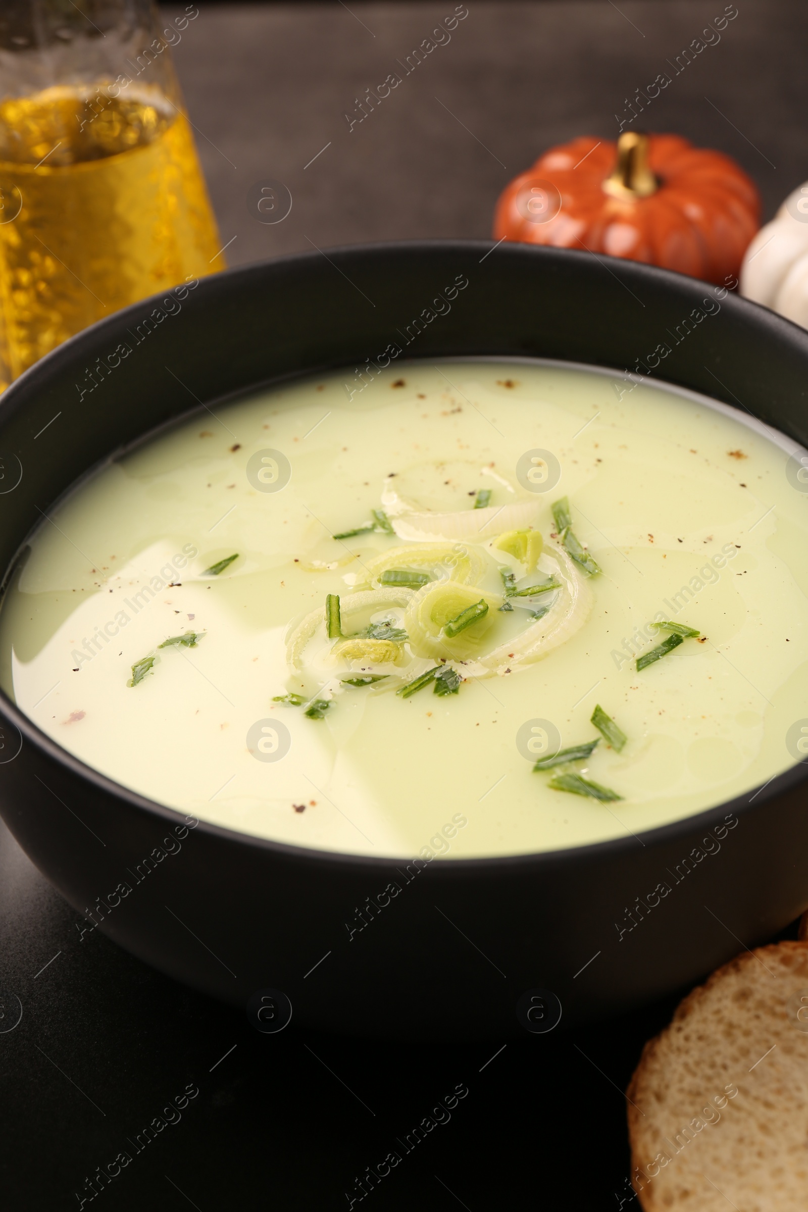 Photo of Bowl of tasty leek soup on table, closeup