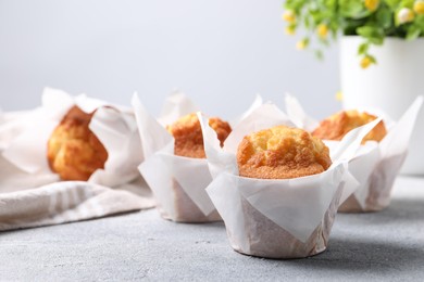 Photo of Delicious sweet muffins on light grey textured table, closeup. Space for text