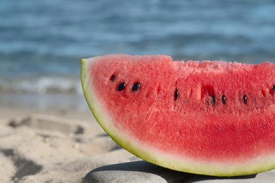 Photo of Slice of fresh juicy watermelon near sea, closeup