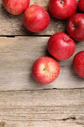 Fresh red apples on wooden table, flat lay. Space for text