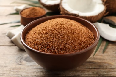 Photo of Natural coconut sugar in bowl on wooden table