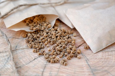 Photo of Paper bags with beet seeds on wooden background, closeup. Vegetable planting