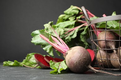 Photo of Whole ripe beets on black table. Organic vegetable