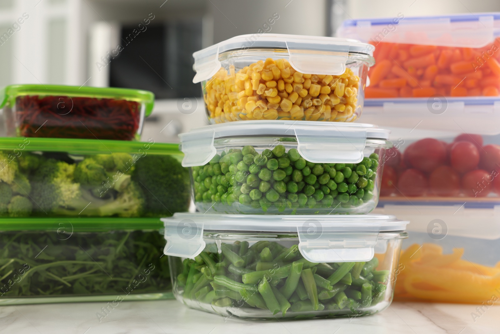 Photo of Glass and plastic containers with different fresh products on white marble table. Food storage