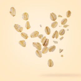 Image of Rolled oat flakes falling on beige background