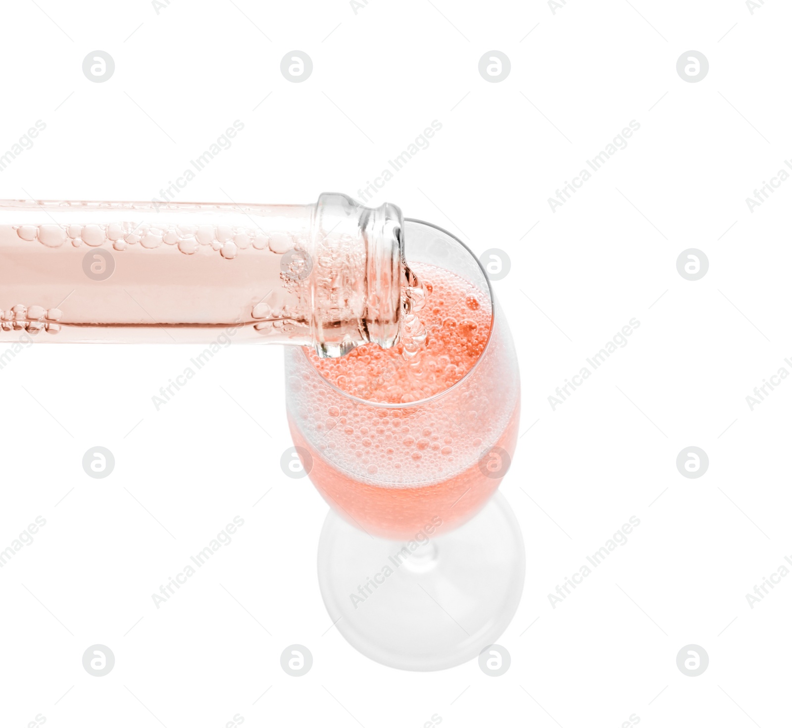 Photo of Pouring rose champagne from bottle into glass on white background