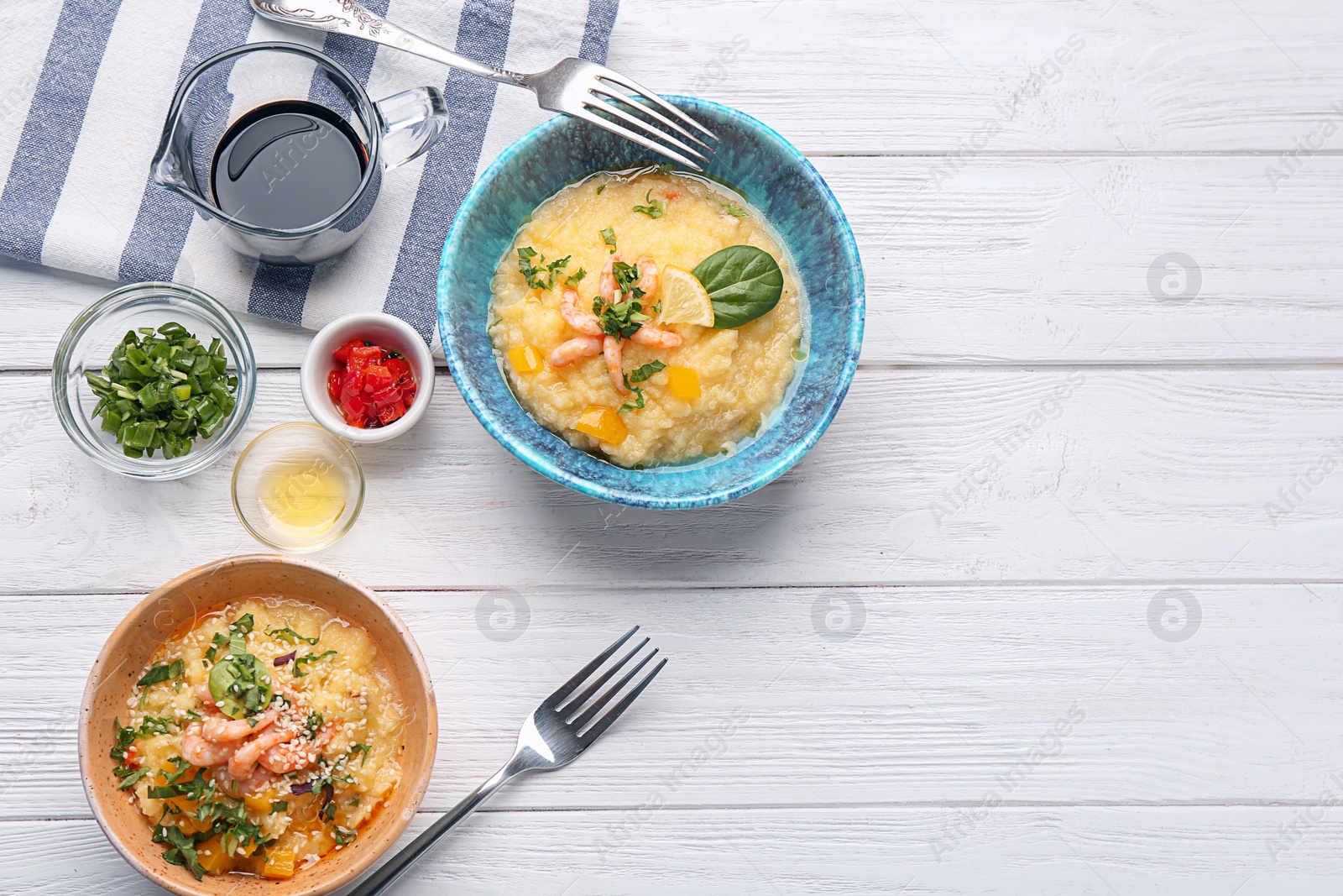 Photo of Bowls with tasty shrimps and grits on table, top view