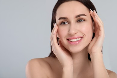 Portrait of beautiful young woman on light grey background. Space for text