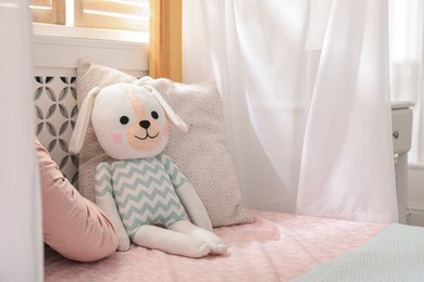 Photo of Toy dog on bed in child's room. Space for text